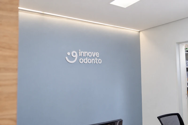 Parede da recepção com a marca Innove Odonto iluminada.
